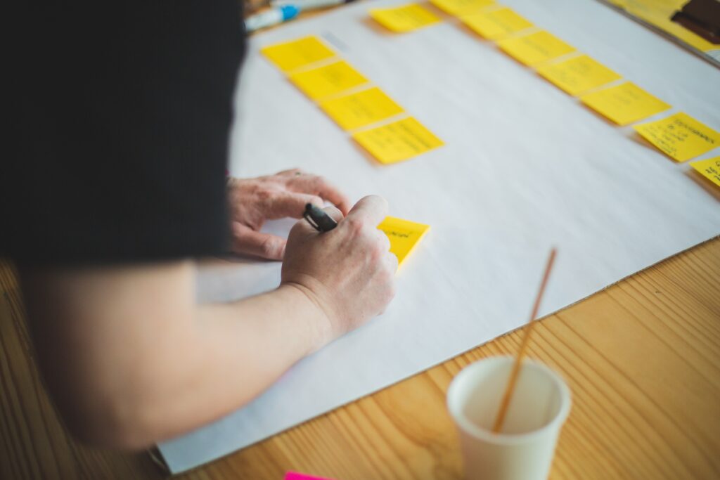 un homme écrit sur un post it